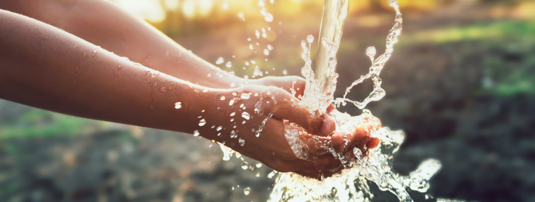 Agua cayendo en unas manos - Cálculo de Huella Hídrica
